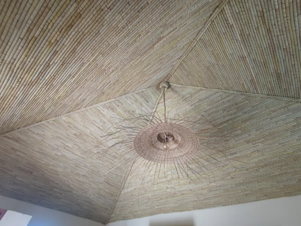 Le Campement Houéfa compte deux villas, avec chacune 3 chambres. Photo du plafond de la chambre numéro 3, à l'étage, réalisé en boudins de palmier rônier, fruit de l'artisanat local.