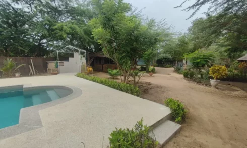 Campement Houéfa entrée donnant sur l'espace piscine ainsi qu'un jardin fleur et arboré